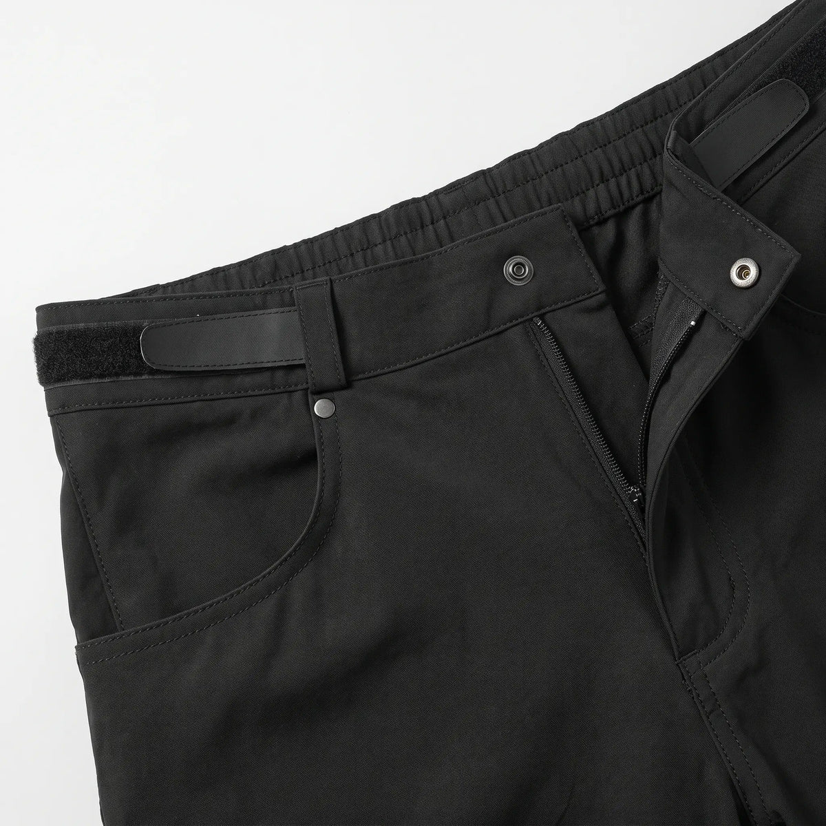 Close-up of the snap button, zip fly and hook-and-loop waist adjuster