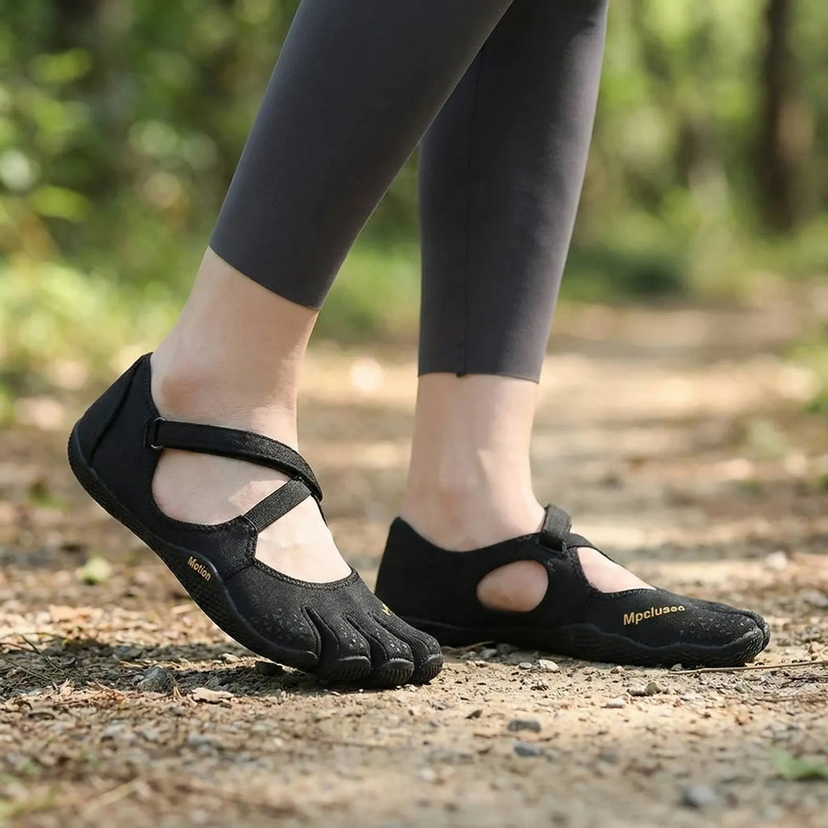 Woman walking on a forest path in the five toe shoes in Black