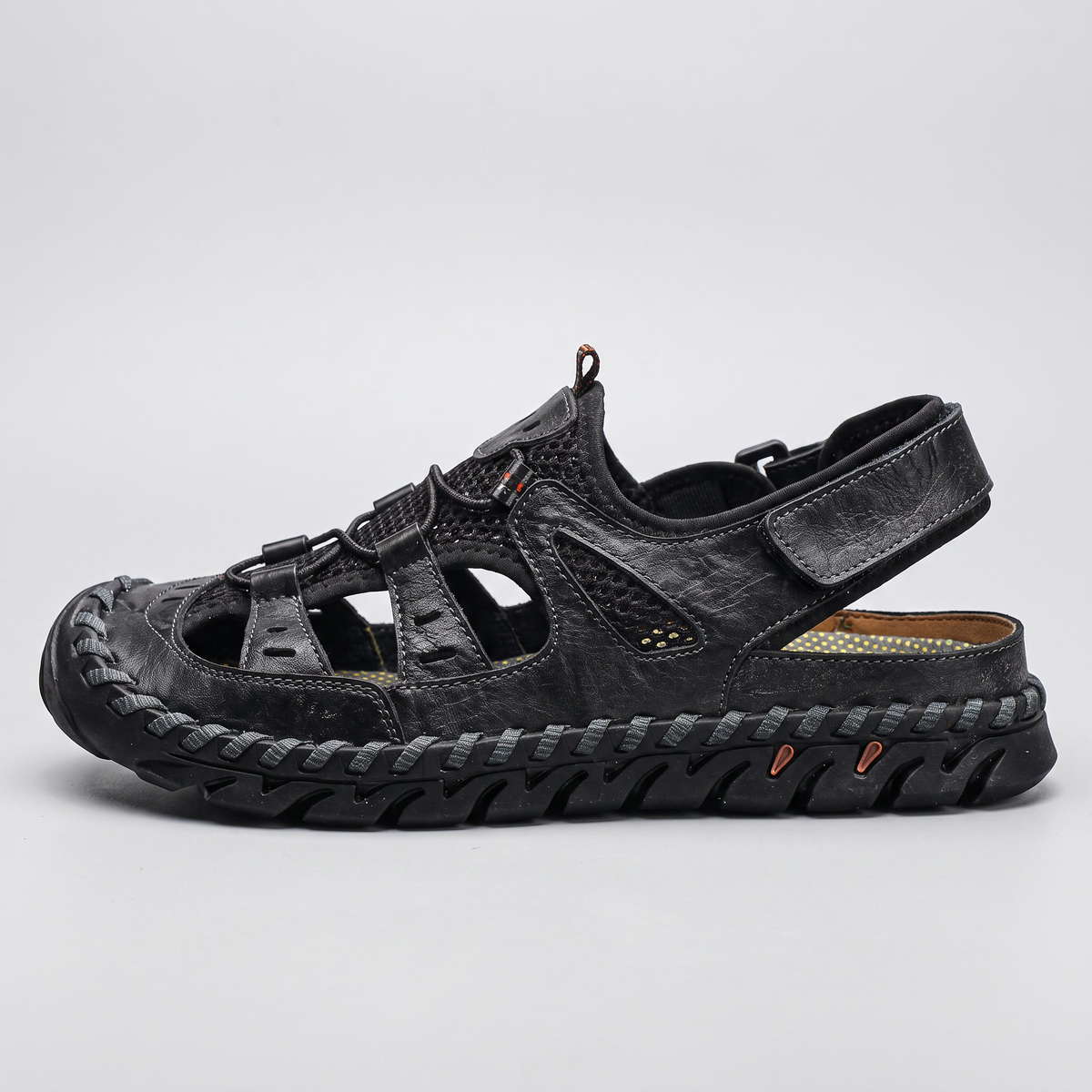 Side profile of the black closed-toe sandal showing the lugged midsole