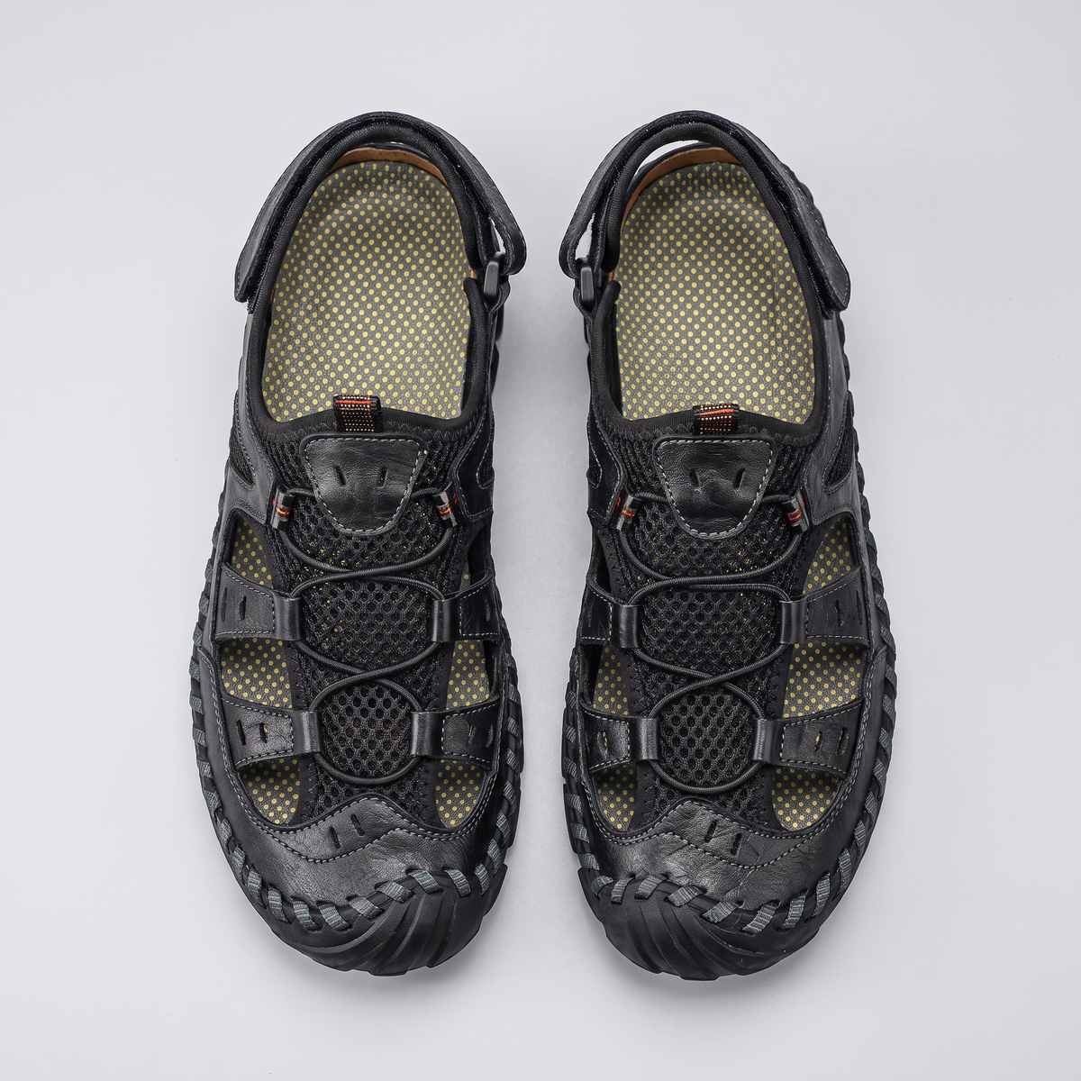 Men's closed-toe leather and mesh sandals in black, top-down pair